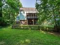 Spacious backyard showcasing a fenced yard, brick patio and second story screened in porch at 816 Roanoke Dr, Cary, NC 27513
