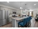 Open kitchen flows into living area with granite countertops, stainless steel appliances and pendant lighting at 820 Laurel Gate Dr, Wake Forest, NC 27587