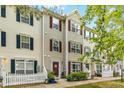 Inviting townhouse with colorful front doors, surrounded by well-kept garden beds and a picket fence at 8640 Neuse Landing Ln # 110, Raleigh, NC 27616