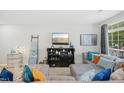 Bright living room with cozy gray sectional, throw pillows, a modern entertainment center, and ample natural light at 8640 Neuse Landing Ln # 110, Raleigh, NC 27616