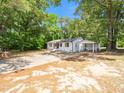 Wide angle view of a home featuring white brick, a metal roof, and a convenient carport at 8731 Raleigh, Benson, NC 27504