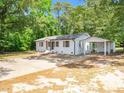 Angle view of the home, showcasing white brick, a metal roof, and a convenient carport at 8731 Raleigh, Benson, NC 27504