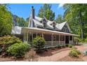 Charming two-story home with a metal roof and a welcoming front porch, complemented by manicured landscaping at 9625 Collins Creek Dr, Chapel Hill, NC 27516