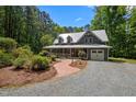 Stunning exterior showcasing a home with a metal roof, long front porch, and beautiful brick walkway and landscaping at 9625 Collins Creek Dr, Chapel Hill, NC 27516