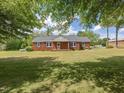A beautiful red brick home is framed by mature trees, offering a serene and inviting atmosphere at 10186 W Nc-97 Hwy, Middlesex, NC 27557