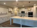 Bright, modern kitchen featuring stainless appliances, large island, and ample white cabinetry at 1024 Channel Drop, Zebulon, NC 27597
