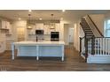 Bright, modern kitchen with stainless appliances, quartz island, and stylish pendant lighting at 1024 Channel Drop, Zebulon, NC 27597