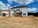 The backyard shows a new build with a covered porch and unfinished landscape at 109 Moonflower Ln # Homesite 260, Wilson's Mills, NC 27520