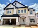 New two-story home with stone accents, a two-car garage, and a covered entryway at 109 Moonflower Ln # Homesite 260, Wilson's Mills, NC 27520