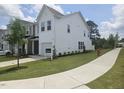 Exterior view of a two-story townhome with a well-maintained lawn and neighborhood sidewalk at 12 Lavender Ln, Clayton, NC 27520