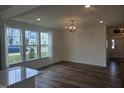 Bright living room with large windows, hardwood floors, and modern light fixture at 12 Lavender Ln, Clayton, NC 27520