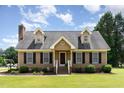 Charming Cape Cod-style home with dormers, black shutters, brick chimney, and a lush green lawn at 123 Sanders Road Rd, Benson, NC 27504