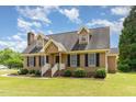 Charming Cape Cod-style home with dormers, black shutters, brick chimney, and a lush green lawn at 123 Sanders Road Rd, Benson, NC 27504