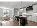 Bright kitchen features a central island with seating, pendant lights, and modern white cabinets at 15 Willow Bend Dr, Youngsville, NC 27596