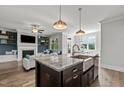 Kitchen island featuring gray veined granite countertops and a stainless steel farm sink at 15 Willow Bend Dr, Youngsville, NC 27596