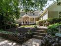 Inviting two-story home with a covered porch, stone-lined garden and mature trees at 1605 Park Dr, Raleigh, NC 27605
