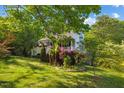 Charming two-story home with red shutters, lovely landscaping, and a lush lawn surrounded by mature trees at 1924 Strebor St, Durham, NC 27705