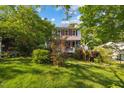 Charming two-story home with red shutters, lovely landscaping, and a lush lawn surrounded by mature trees at 1924 Strebor St, Durham, NC 27705