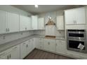 Bright kitchen with white cabinets, gray countertops, and stainless steel appliances at 214 Alden Way, Angier, NC 27501