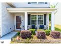 Inviting front porch with seating area and well-maintained landscaping at 224 Brisk Dr, Zebulon, NC 27597