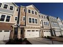 New townhome with attached garage and a mixed material facade of siding and brick under a clear blue sky at 2297 Bay Minette Sta # 536, Apex, NC 27502