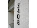 Modern black address numbers displayed vertically on the painted brick facade of the new home at 2408 Eagle Shot Ct # 4, Fuquay Varina, NC 27526