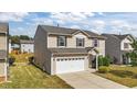 Side view of a two-story home featuring neutral siding, a two-car garage, and a well manicured lawn at 2522 Dalmahoy Ln, Fuquay Varina, NC 27526