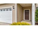 Exterior view of front door and garage with white door, brown door, and manicured shrubbery at 2522 Dalmahoy Ln, Fuquay Varina, NC 27526