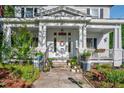 Inviting front entrance with colorful floral decorations, railing, and multiple potted plants at 302 Villa St, Rocky Mount, NC 27804