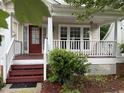 Charming front porch with a red door, white railings, and inviting curb appeal at 3032 Kilarney Ridge Loop, Cary, NC 27511