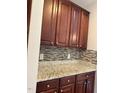 Close up of kitchen with granite countertops, mosaic tile backsplash, and dark wood cabinets at 3032 Kilarney Ridge Loop, Cary, NC 27511