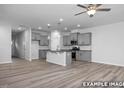 Bright, open kitchen and living area featuring gray cabinets, granite countertops, and wood flooring at 3918 Well Fleet Dr, Fuquay Varina, NC 27526