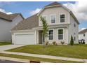 Charming home with an attached garage, manicured lawn, and fresh landscaping with a young tree at 392 Peach Grove Way, Lillington, NC 27546