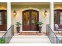 Inviting front entrance with double wood doors, lantern sconces and elegant porch setting at 403 Granville Rd, Chapel Hill, NC 27514