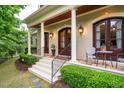 Inviting front entrance with double wood doors, lantern sconces and elegant porch setting at 403 Granville Rd, Chapel Hill, NC 27514