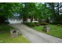 Long driveway leading to a spacious three-car garage, surrounded by lush greenery at 4113 Oak Park Rd, Raleigh, NC 27612