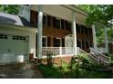 Attractive brick home with a white front porch, complemented by a spacious three-car garage at 4113 Oak Park Rd, Raleigh, NC 27612