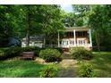 Beautifully landscaped front yard with mature trees, lush lawn, and a charming brick walkway at 4113 Oak Park Rd, Raleigh, NC 27612