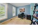 Bright office with natural light featuring a black desk, shelving, and soothing blue walls at 420 Marsh Landing Dr, Holly Springs, NC 27540