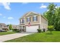 Well-maintained two-story home featuring an attached garage, American flag, and landscaped front yard at 4221 Northrop Dr, Haw River, NC 27258