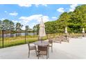Pool deck with seating and sun loungers overlooking a pond, perfect for relaxation and community enjoyment at 46 Black Walnut Dr # 197, Garner, NC 27529
