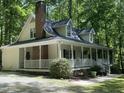 Two story home featuring a screened-in porch, brick chimney and mature trees at 524 Preston Andrews Rd, Bahama, NC 27503