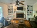 Cozy living room featuring a brick fireplace, custom built-ins, and hardwood floors at 524 Preston Andrews Rd, Bahama, NC 27503