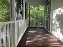 View of a screened porch with white rails overlooking lush, wooded backyard at 524 Preston Andrews Rd, Bahama, NC 27503