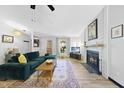 Comfortable living room with a fireplace, a cozy sofa, and large windows providing ample natural light at 5300 Whippoorwill St, Durham, NC 27704
