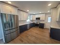 Renovated kitchen with stainless steel appliances, two-tone cabinets, backsplash, and wood-look flooring at 5718 Woodcrest Dr, Raleigh, NC 27603