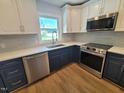 Modern kitchen features two-tone cabinets, stainless steel appliances, quartz counters, and a tiled backsplash at 5718 Woodcrest Dr, Raleigh, NC 27603
