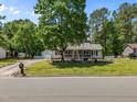 Charming single-story home with a screened front porch, detached garage, and mature trees enhancing the curb appeal at 609 Chivalry Dr, Durham, NC 27703