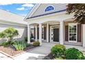 Close-up of the front porch with elegant columns, a well-maintained garden, and a welcoming entranceway at 716 Arbor Brook Dr, Cary, NC 27519