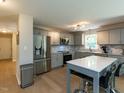The kitchen features stainless steel appliances, gray cabinetry, and an island that seats two at 801 Madison Ave, Cary, NC 27513
